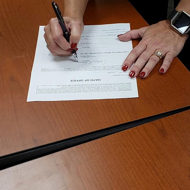Cathy signing her oath of office
